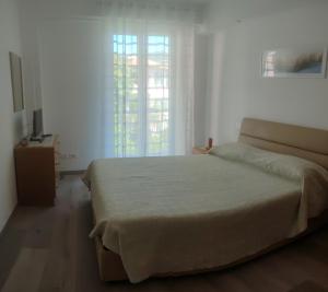 a bedroom with a large bed and a window at Da Fede al mare in Moneglia