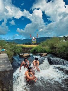 a group of four men playing in a waterfall at Tani Adventure in Ziro +7 photos