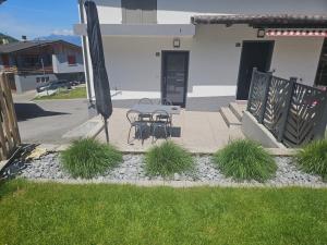 a patio with a table and chairs in a yard at Studio Cime de l'Est in Vérossaz +1 photo