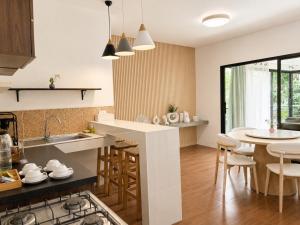 a kitchen with a sink and a table with chairs at Field-D House in Ko Tao