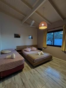 a bedroom with two beds and a chandelier at 1991HospedajeD3 in Ensenada