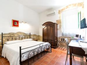 a bedroom with a bed and a table and a desk at A Lumia in Noto
