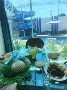 a table with plates of food and drinks on a balcony at Casa suites golden in Tonsupa