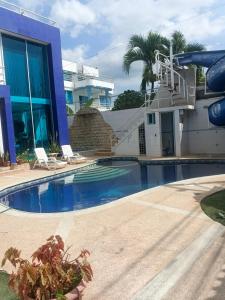 a swimming pool in front of a house at Casa suites golden in Tonsupa