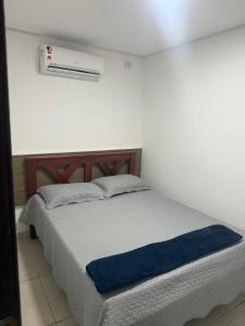 a bedroom with a bed with a blue blanket at Flats Olinda Vista Mar in Olinda