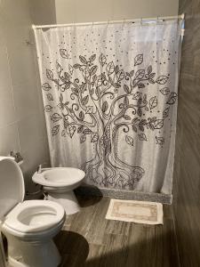 a bathroom with a shower curtain with a tree at 1991HospedajeD3 in Ensenada +46 photos
