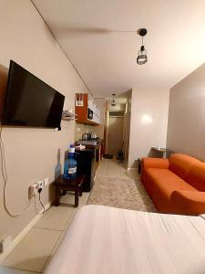 a living room with a couch and a flat screen tv at Reinastays in Kiambu