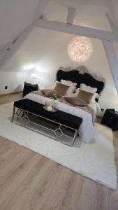 a bedroom with a large bed and a chandelier at Le cocoon de choupette in Cuvilly