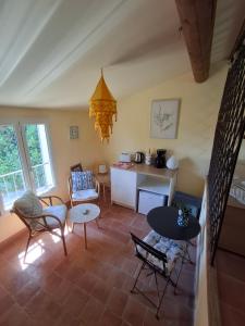 a living room with tables and chairs and a kitchen at Casa Doudou in Bédoin