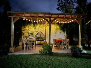 a pergola with a table and chairs in a yard at A-Frame tiny house in Arusha