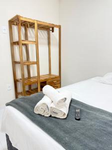 a bed with two towels and a cell phone on it at Flats Ana Alves Residence Delta do Parnaíba- Piauí in Parnaíba +24 photos