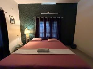 a bedroom with a large bed with a red blanket at Villa Mud Apple in Varkala