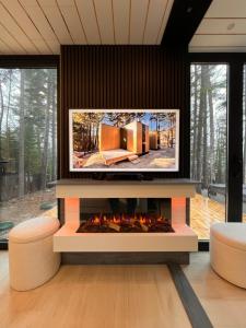 a living room with a tv above a fireplace at The Lake Villa in Ingramport