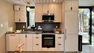 a kitchen with white cabinets and a stove top oven at The Lake Villa in Ingramport +40 photos