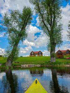 a yellow kayak in a lake with houses in the background at Zatoka Warmii in Tomaszkowo