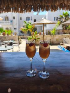 two wine glasses sitting on top of a table at Miramare Boutique Apartments in Platanias