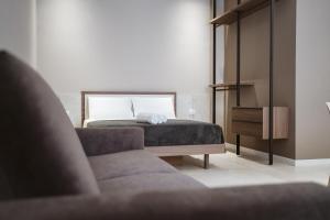 a bedroom with a bed and a couch at MEANDRI Apartment in San Severo