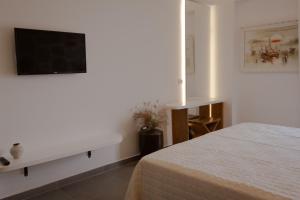 a bedroom with a bed and a tv on a wall at Sunset Serenity in Himare