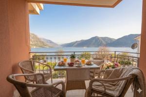 a table and chairs on a balcony with a view of the water at Sea Nook in Trstenik
