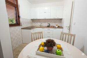 a kitchen with a table with a bowl of fruit on it at Sea Nook in Trstenik