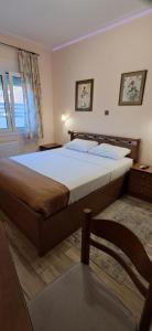 a bedroom with a large bed and a chair at Simos in Vrontádos