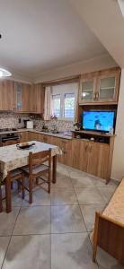 a large kitchen with a table and a tv at Simos in Vrontádos +11 photos