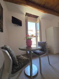 a table and chairs in a room with a window at Casa Rubini in Paestum