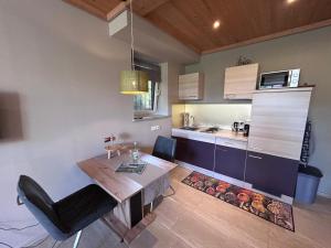 a kitchen with a wooden table and a dining room at FeWo Marielle in Seeboden