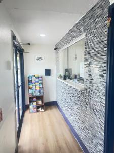 a room with a brick wall and a shelf with books at Bourne Bridge Inn Former Eastern Inn in Bourne