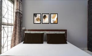 a bedroom with a bed with four pictures on the wall at Park's Hotel Mbd in Morādābād