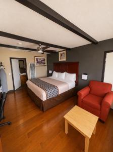 a hotel room with a bed and a red chair at Buffalo Inn Vintage MOTEL in Canyon