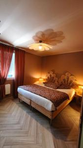 a bedroom with a large bed with a ceiling at L Atelier du zoo in Sablons