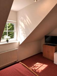 an attic room with a television and a window at Hotel Marislav in Češnovice