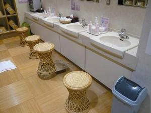 a bathroom with three sinks and three stools at Izuajiro-onsen Shoufuen in Atami