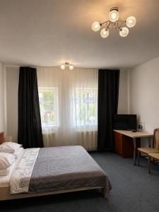 a bedroom with a bed and a window and a desk at Hotel Marislav in Češnovice