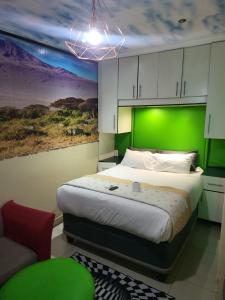 a bedroom with a large bed with a green wall at Tshedza Guest House in Pretoria +67 photos