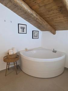 a large white bath tub in a bathroom with a wooden ceiling at Casa Rubini in Paestum +75 photos