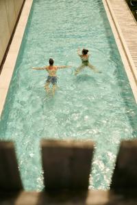 two people are swimming in a swimming pool at Hirben Naturlaub in Villabassa