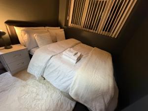 a bedroom with a bed with white sheets and a window at Dudley Retreat in Dudley