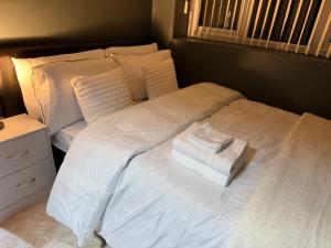 a white bed with two towels on top of it at Dudley Retreat in Dudley