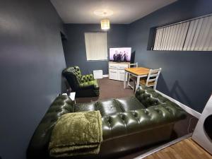 a living room with a leather couch and a table at Dudley Retreat in Dudley