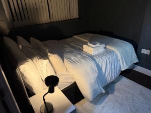 a bedroom with a bed with white sheets and towels at Dudley Retreat in Dudley