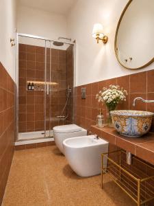 a bathroom with a toilet and a sink and a mirror at ISOLA - Smart Accomodation in Messina