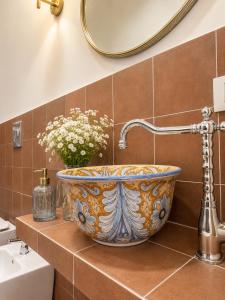 a bathroom with a bowl sink and a mirror at ISOLA - Smart Accomodation in Messina