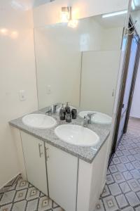 a bathroom with two sinks and a mirror at Me Gusta Sucre Inn in Sucre