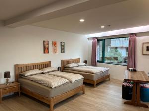 a bedroom with two beds and a window at Jing Zhan in Jiufen