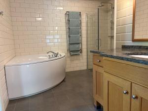 a white bathroom with a tub and a sink at Tornvillan in Mariehamn +21 photos
