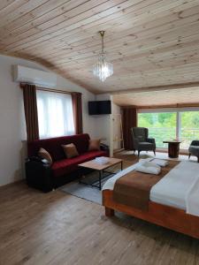a bedroom with a bed and a red couch at Ayder River Suite by Karadeniz in Ardeşen +24 photos