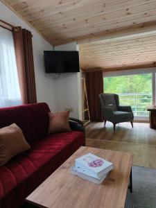 a living room with a red couch and a table at Ayder River Suite by Karadeniz in Ardeşen