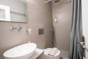 a bathroom with a toilet and a sink and a shower at Kamarela Studios in Kamari
